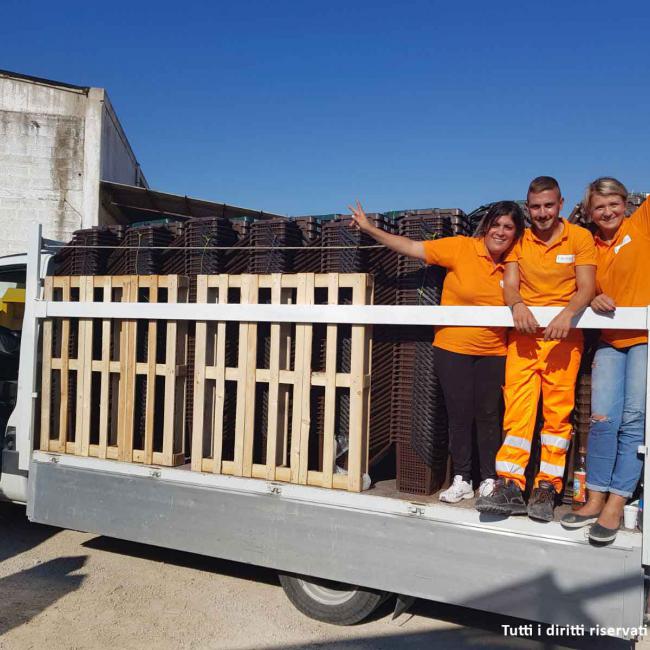 operatori ecologici su camion che trasporta bidoni per la differenziata